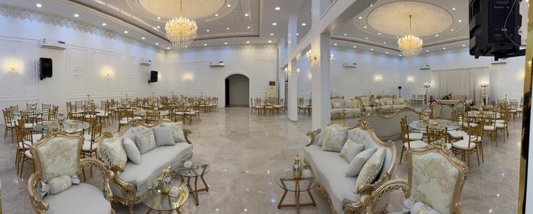 Elegant ballroom with gold chairs, cream sofas, chandeliers, and polished marble floor